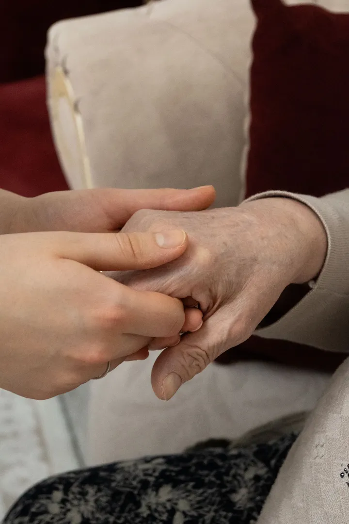 Two pairs of hands held together, one older, one younger