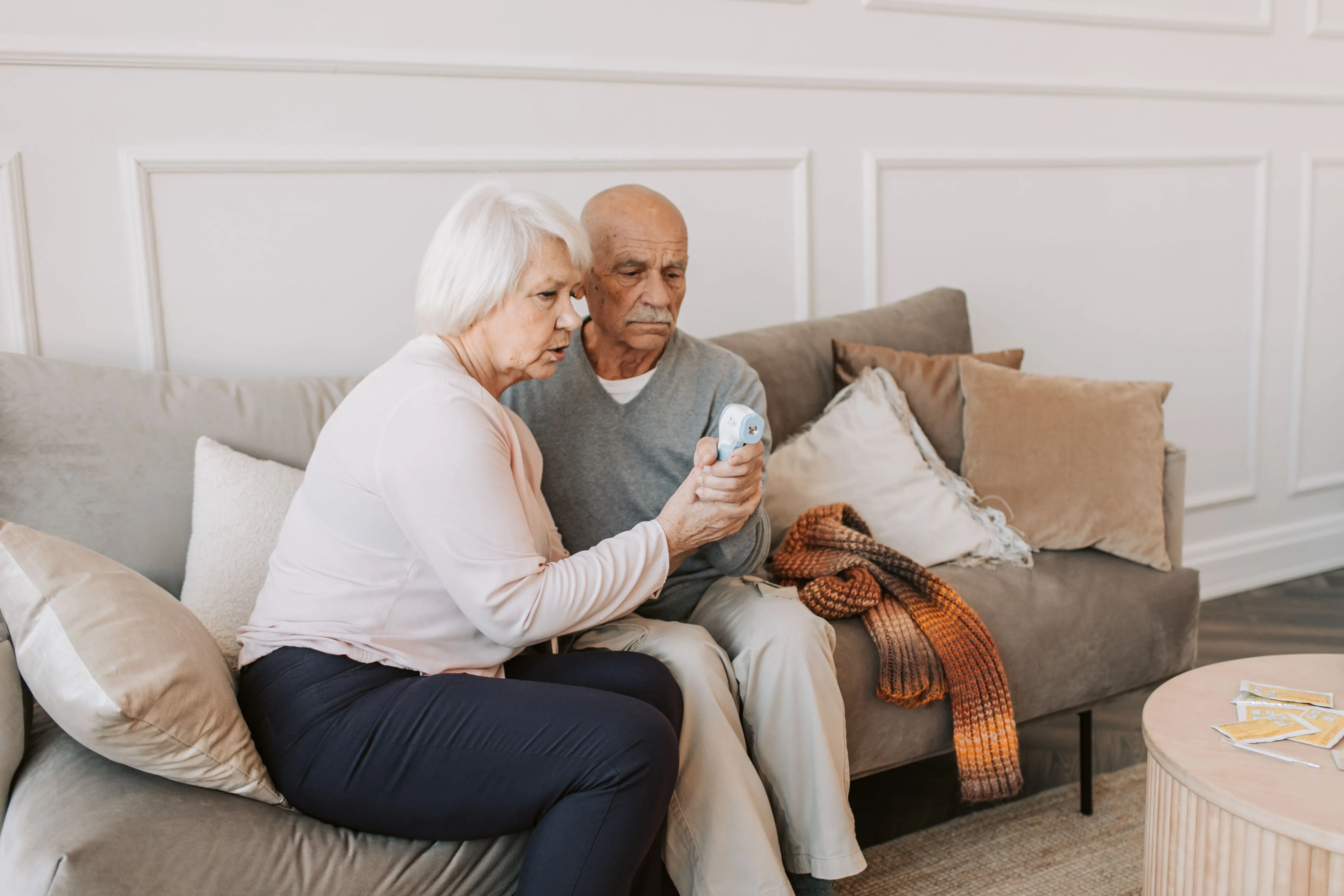 Senior woman taking a health reading for her partner at home